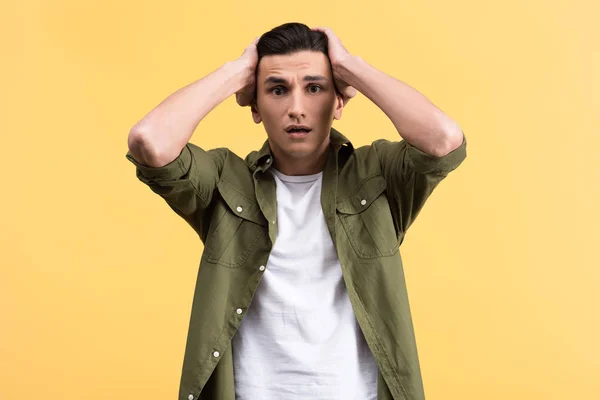 Portrait of worried young man, isolated on yellow — Stock Photo