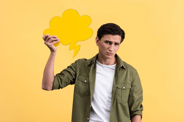 Homem confuso segurando bolha fala nuvem, isolado em amarelo — Fotografia de Stock