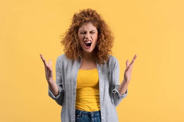 Aggressive shouting redhead girl, isolated on yellow — Stock Photo