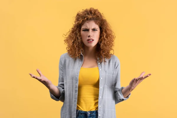 Fille rousse inquiète avec geste d'haussement d'épaules, isolée sur jaune — Photo de stock