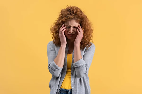 Beautiful redhead upset girl crying isolated on yellow — Stock Photo