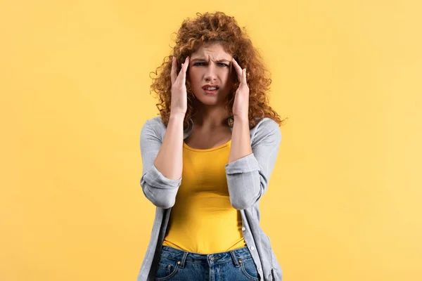 Chica pelirroja estresada con dolor de cabeza aislado en amarillo - foto de stock