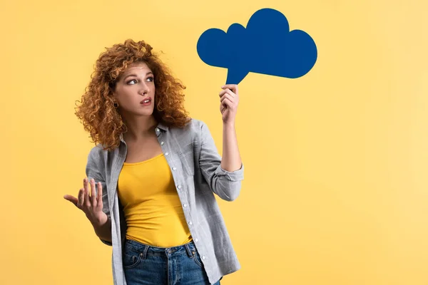 Skeptische Frau blickt auf leere Sprechblase in Form einer Wolke, isoliert auf gelb — Stockfoto