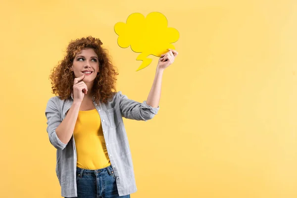 Мрійлива дівчина дивиться на порожню бульбашку мови у формі хмари, ізольована на жовтому — стокове фото
