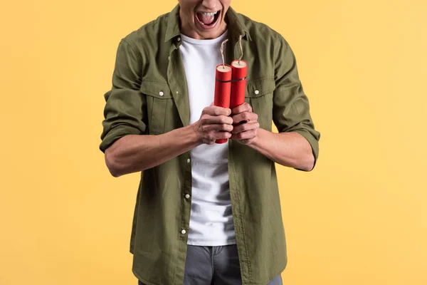 Cropped view of angry man yelling and holding dynamite sticks, isolated on yellow — Stock Photo