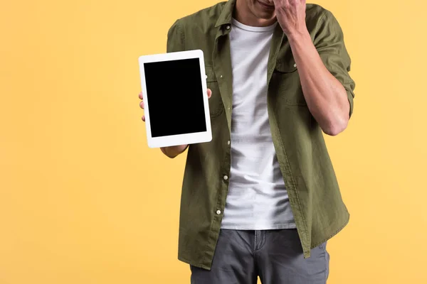 Cropped view of man showing digital tablet with blank screen, isolated on yellow — Stock Photo