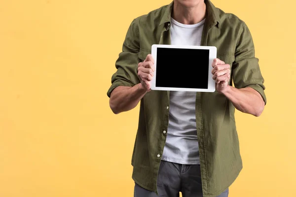 Cropped view of man showing digital tablet with blank screen, isolated on yellow — Stock Photo