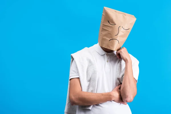 Homem pensativo com saco de papel na cabeça, isolado em azul — Fotografia de Stock