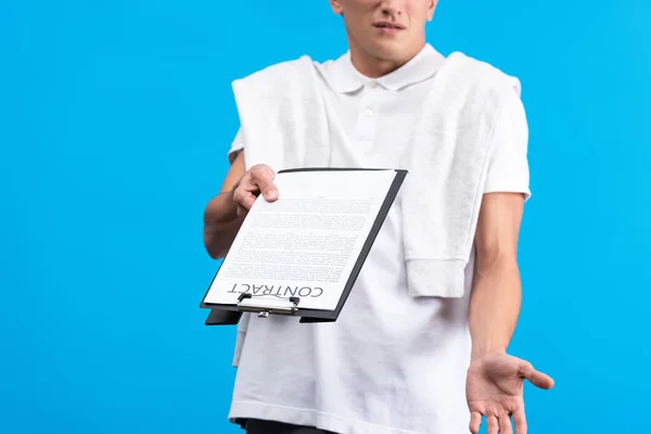 Обрезанный вид запутанного человека, держащего планшет с контрактом, изолированный на синий — стоковое фото