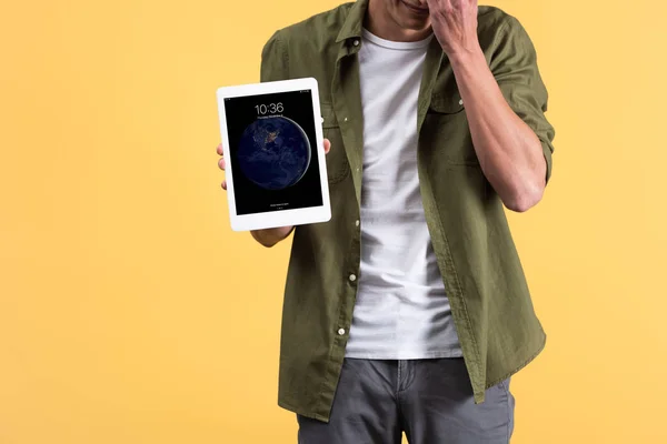 KYIV, UKRAINE - NOVEMBER 18, 2019: cropped view of man showing digital tablet with screen, isolated on yellow — Stock Photo