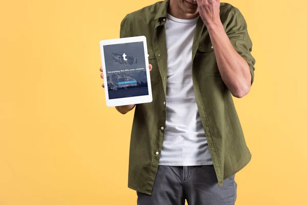 KYIV, UCRÂNIA - NOVEMBRO 18, 2019: visão recortada do homem mostrando tablet digital com aplicativo tumblr na tela, isolado em amarelo — Fotografia de Stock