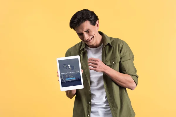 KYIV, UKRAINE - NOVEMBER 18, 2019: stressed man crying and showing digital tablet with tumblr app on screen, isolated on yellow — Stock Photo