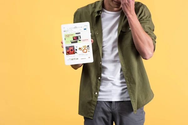 KYIV, UKRAINE - NOVEMBER 18, 2019: cropped view of man showing digital tablet with ebay app on screen, isolated on yellow — Stock Photo