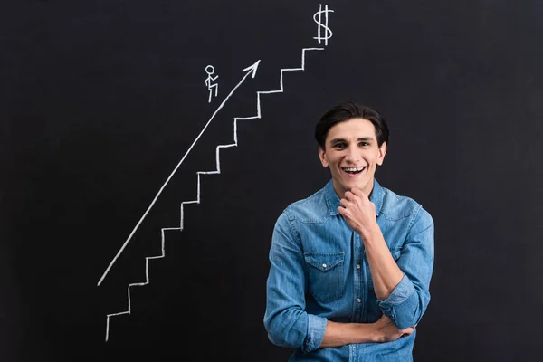 Hombre pensativo feliz con crecimiento del negocio dibujando en pizarra - foto de stock