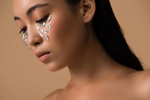 Beautiful naked asian girl with rhinestones on face isolated on beige — Stock Photo