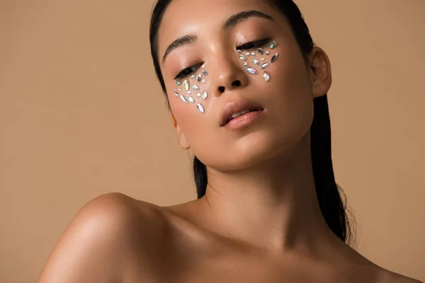 Beautiful naked asian girl with rhinestones on face isolated on beige — Stock Photo