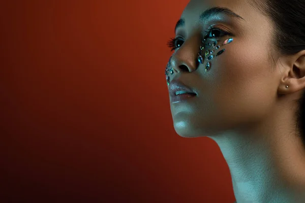 Beautiful asian girl with shiny rhinestones on face looking away — Stock Photo