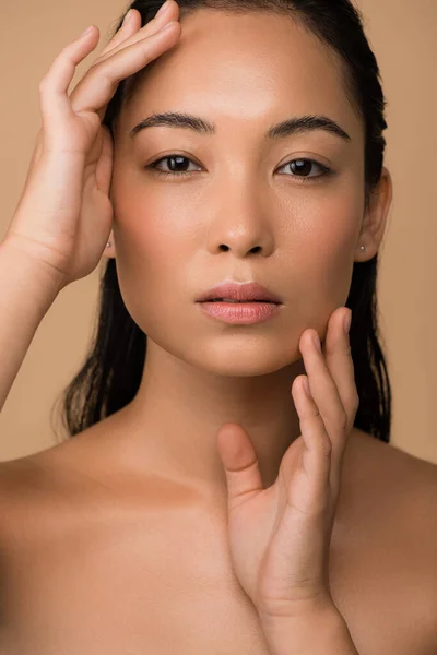 Beautiful naked asian girl touching face isolated on beige — Stock Photo