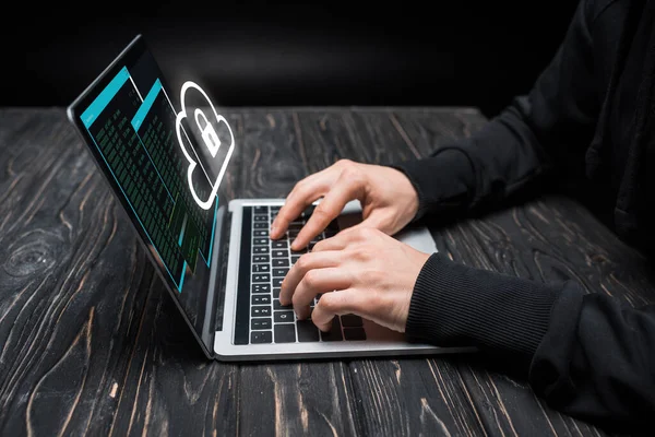 Vista cortada de hacker usando laptop com nuvem e cadeado em preto — Fotografia de Stock