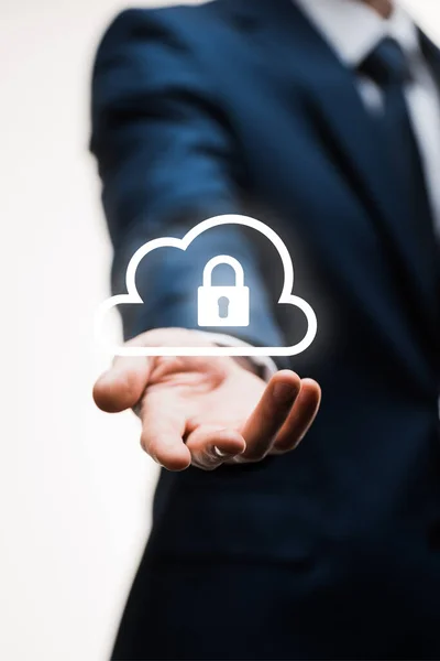 Cropped view of businessman in suit with outstretched hand near cloud with padlock on white — Stock Photo