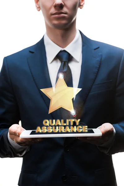 Cropped view of businessman holding digital tablet near quality assurance lettering on white — Stock Photo