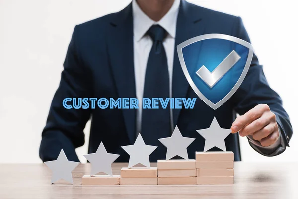 Cropped view of businessman in formal wear touching star near customer review lettering on white, quality concept — Stock Photo