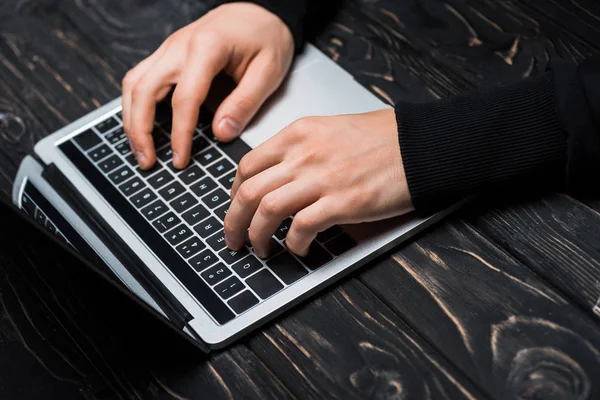 Vista recortada del hacker escribiendo en el teclado del ordenador portátil - foto de stock