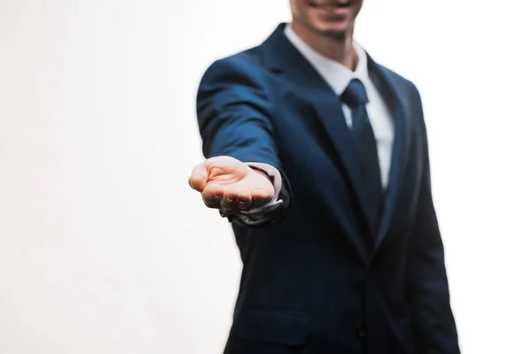 Enfoque selectivo de hombre de negocios feliz en traje que muestra la mano ahuecada aislado en blanco - foto de stock