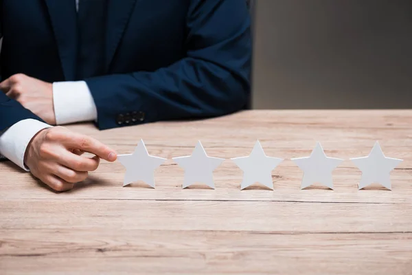 Abgeschnittene Ansicht eines Mannes in formaler Kleidung, der mit dem Finger auf Stern zeigt, isoliert auf Grau, Qualitätskonzept — Stockfoto