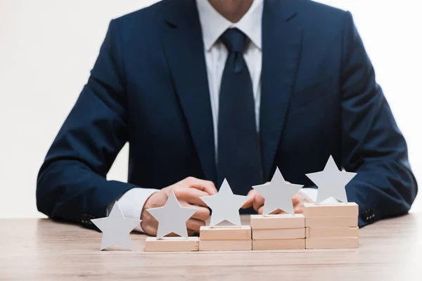 Vista cortada de empresário em desgaste formal sentado perto de estrelas isoladas em branco, conceito de qualidade — Fotografia de Stock