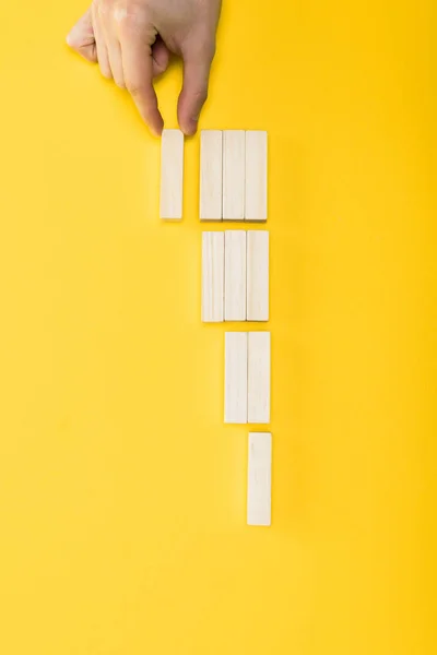 Top view of man holding wooden block isolated on yellow — Stock Photo