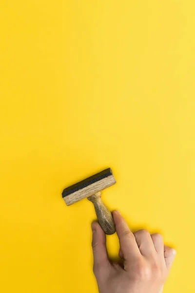 Vista superior del hombre sosteniendo sello aislado en amarillo, concepto de calidad - foto de stock