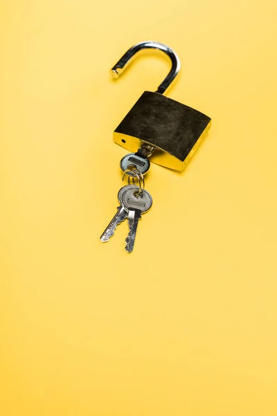 Metallic padlock with keys isolated on yellow — Stock Photo