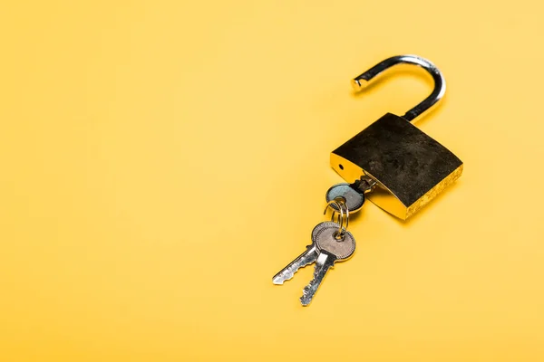 Padlock with keys isolated on yellow — Stock Photo