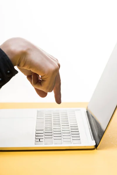 Vista recortada del hombre apuntando con el dedo a la computadora portátil aislado en blanco - foto de stock