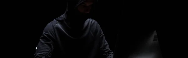 Plano panorámico de hacker encapuchado en máscara en negro - foto de stock