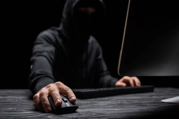 Вибірковий фокус комп'ютерної миші в руці на хакері ізольовано на чорному — стокове фото