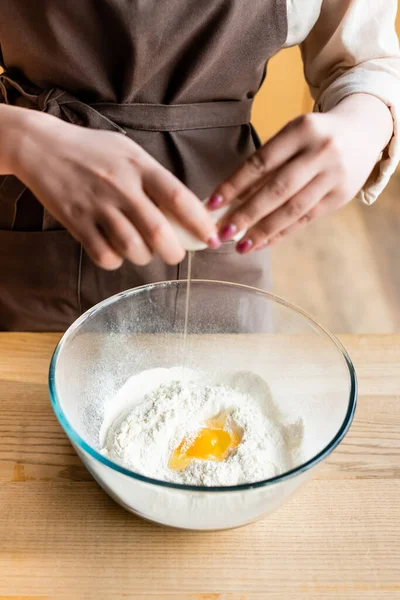 Vista ritagliata della donna che aggiunge uovo crudo in ciotola con farina — Foto stock