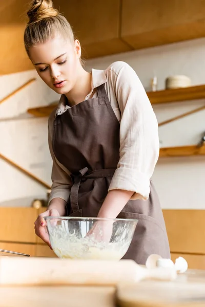 Foco seletivo de mulher atraente amassar massa de farinha em tigela de vidro perto de rolo pin — Fotografia de Stock