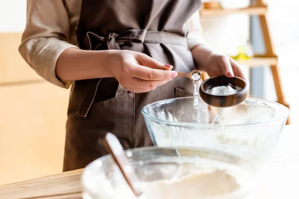 Cropped view of woman adding baking powder in bowl — Stock Photo