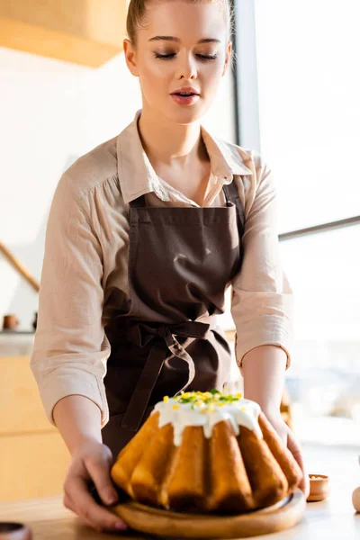 Enfoque selectivo de mujer atractiva sosteniendo pastel de Pascua horneado - foto de stock