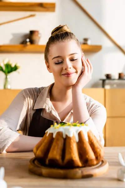 Foco seletivo da mulher feliz olhando para o bolo de Páscoa saboroso — Fotografia de Stock