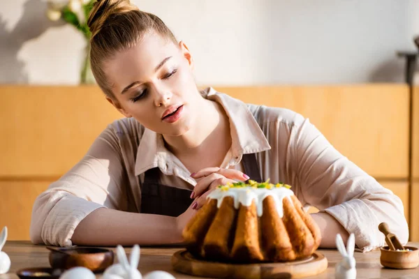 Избирательный фокус привлекательной девушки глядя на вкусный пасхальный торт — стоковое фото