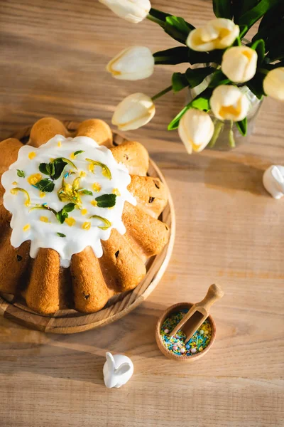 Vue de dessus du gâteau de Pâques près des figurines avec des lapins de Pâques décoratifs et des tulipes — Photo de stock