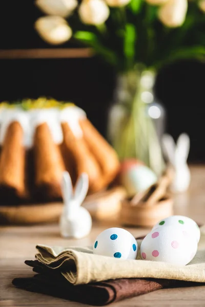 Селективный фокус льняных салфеток с пунктирными яйцами возле пасхального хлеба — стоковое фото