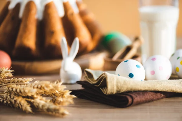 Foco selectivo de servilletas de lino con huevos punteados cerca de pan de Pascua y figurita de conejo - foto de stock