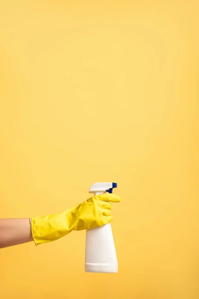 Vista ritagliata della mano femminile in guanto di gomma con bottiglia spray isolata su giallo — Foto stock