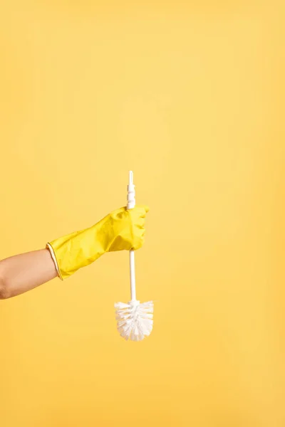 Partial view of woman in rubber glove holding plunger isolated on yellow — Stock Photo