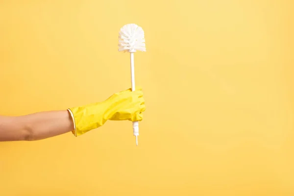 Cropped view of woman in rubber glove holding plunger isolated on yellow — Stock Photo