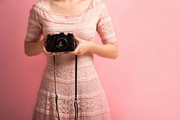 Обрезанный вид фотографа в элегантном платье с цифровой камерой на розовом фоне — стоковое фото